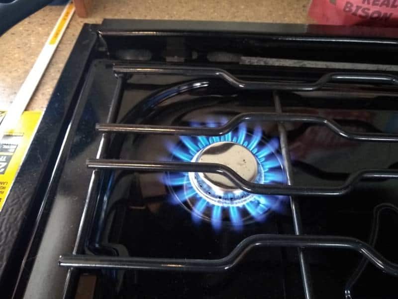 Blue propane flame at RV stove cooktop burner
