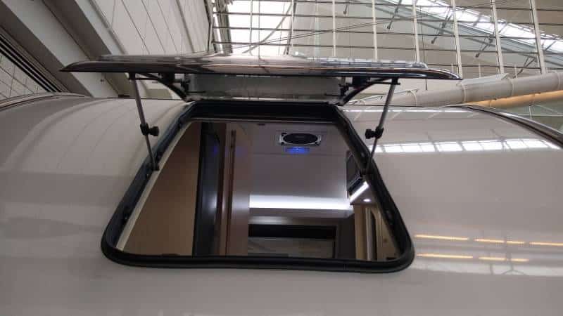 This is a teardrop trailer with a hinged, opening dual-pane window on the curved rear wall.