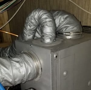 Flexible ducting with sharp 180-degree bends connected to RV furnace case.