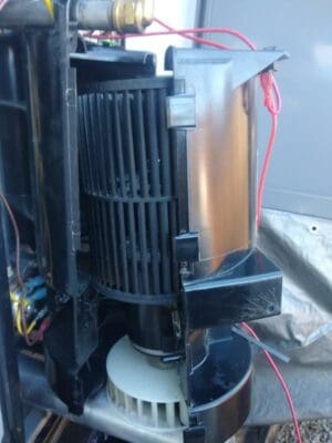 RV furnace blower and combustion wheel attached to motor in housing